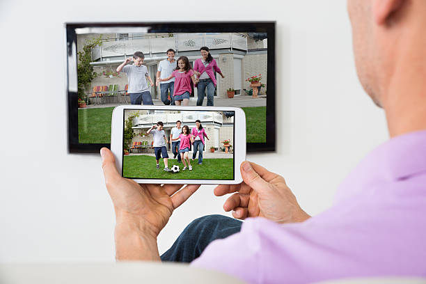 istock Man Holding Smartphone Connected To A TV 598555544