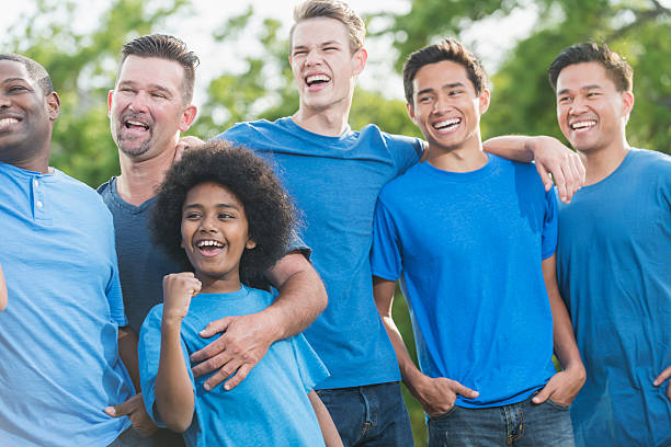 istock Multi-racial group of fathers and sons in blue shirts 598555588