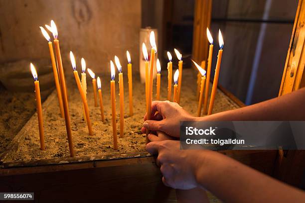 Mother And Child Lighting A Candle In Orthodox Church Stock Photo - Download Image Now