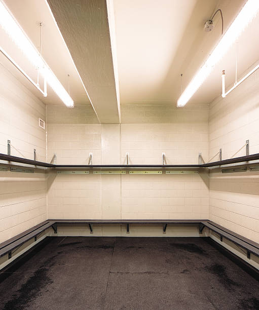 Empty hockey rink sports changing room Empty hockey rink sports changing room with benches and tablets, lit by neons. fitting room stock pictures, royalty-free photos & images