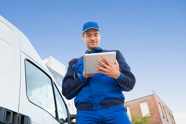 fattorino che usa tablet digitale su camion contro sky - delivery van truck delivering moving van foto e immagini stock