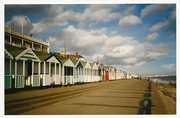 Colorful scene of beach huts on the promenade at Aldeburgh in Suffolk, England. A fairly typical image of an English coastal resort.