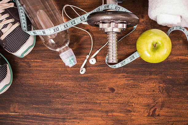 istock Fitness, exercise themed scene with barbells, sneakers, apple. 598565714