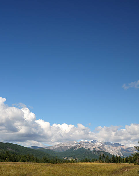 Blue sky and cumulus clouds over the Eastern Sayan Mountains