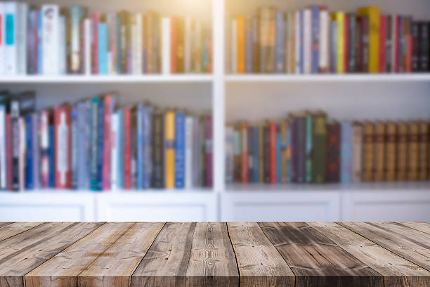 istock Wood table top on blur bookshelf background 598566360