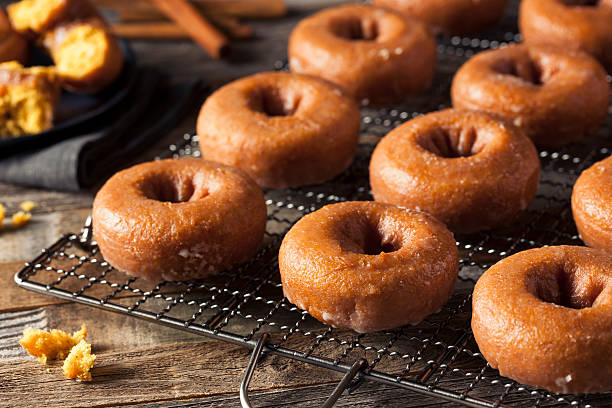 domowe szkliwione jesienne pączki z dyni - donut glazed bakery unhealthy eating zdjęcia i obrazy z banku zdjęć