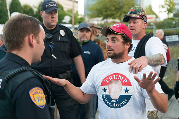 Trump Protest Everett, USA - August 30, 2016: A man in a heated debate with a Police officer at the Donald Trump rally outside the Xfinity Arena in Everett late in the day. everett washington state photos stock pictures, royalty-free photos & images