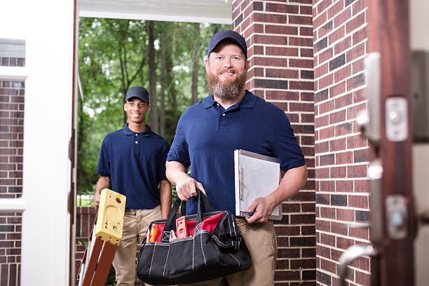 istock Multi-ethnic team of repairmen at customer's front door. 598570840