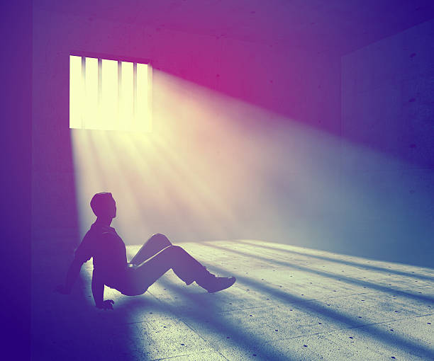 istock prisoner in dark room with light beams 598574834