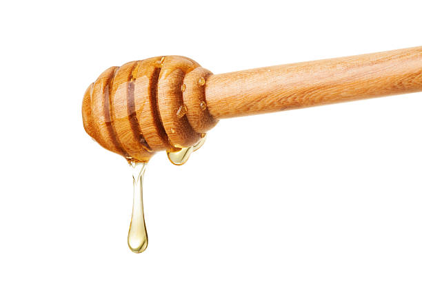 istock Honey dripping from a wooden dipper 598666632