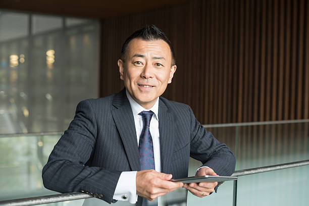 istock Cheerful Japanese businessman with digital tablet, smiling 598668462