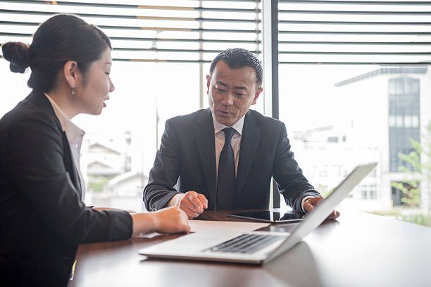 istock Two Japanese business people in office using laptop 598668518