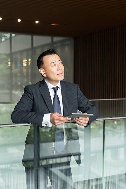 istock Aspirational Japanese businessman with tablet looking away 598668546