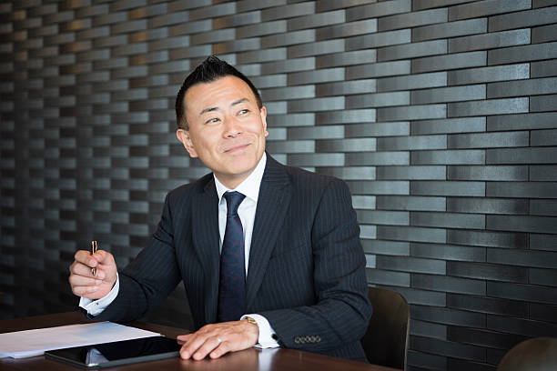 istock Mature Japanese businessman making notes, looking away 598668558