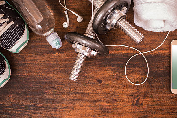 istock Fitness, exercise themed scene with barbells, sneakers, earbuds. 598674738