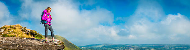 Young hiker on green mountain ridge overlooking panoramic rural view