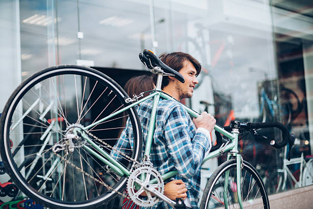 Young man carrying his bike for repair.