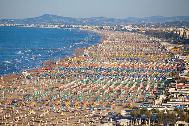 Rimini, Italy - August 24, 2016: Aerial view of beach goers at the beach of Rimini, a seaside resort at the Adriatic coast beloved by Italians and foreigners alike.