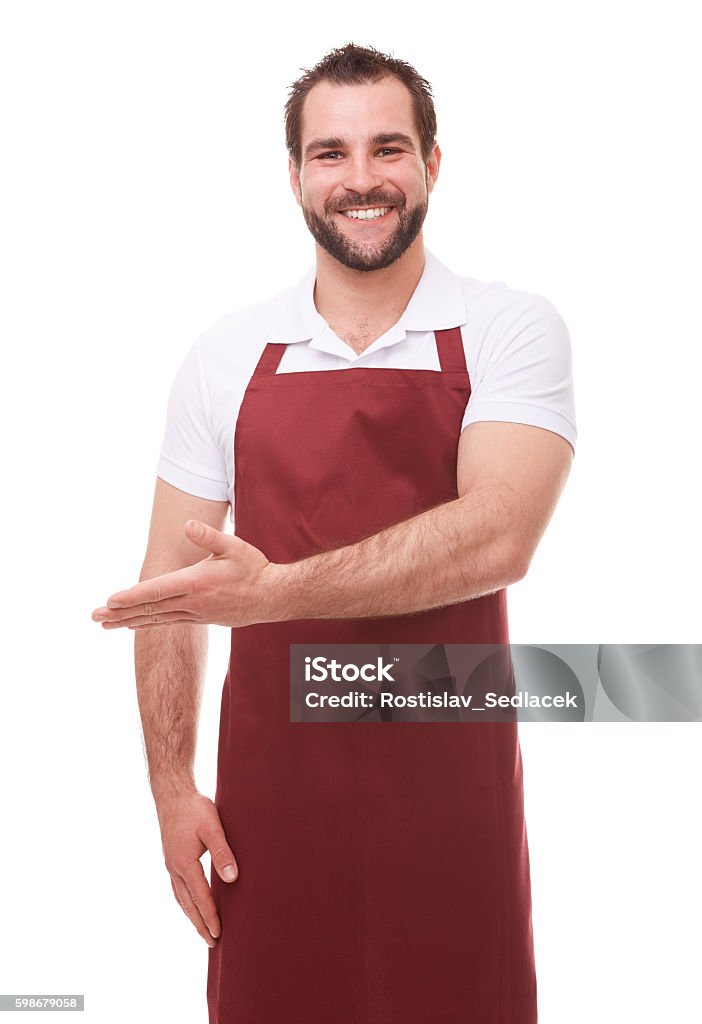 Man with red apron showing empty copyspace Happy man with red apron showing empty copyspace on white background Butcher Stock Photo