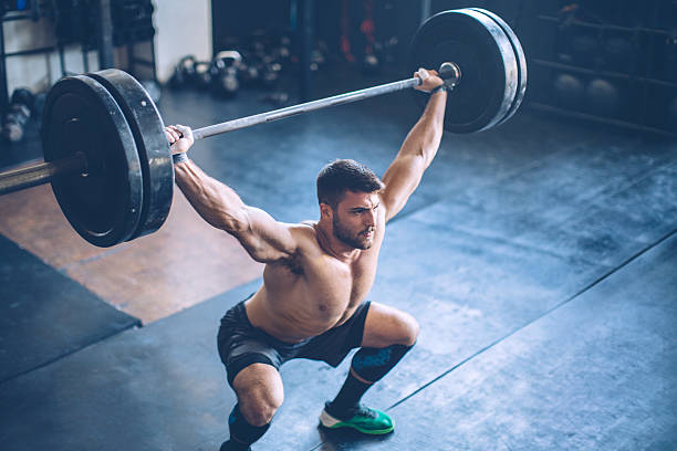 Putting in the hours to get results Young man exercising deadlift in gym. Professional sportists. Wearing sports clothing. crossfit chalk weightlifting weight training stock pictures, royalty-free photos & images