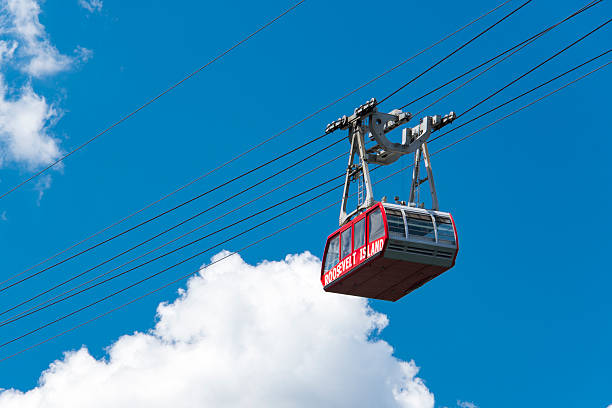 New York City cable car to Roosevelt Island New York, USA - August 7, 2016: Red Tram Car of Roosevelt Island Tramway. The overhead cable car spans the East River and connects Roosevelt Island to tMidtown Manhattan. roosevelt island stock pictures, royalty-free photos & images