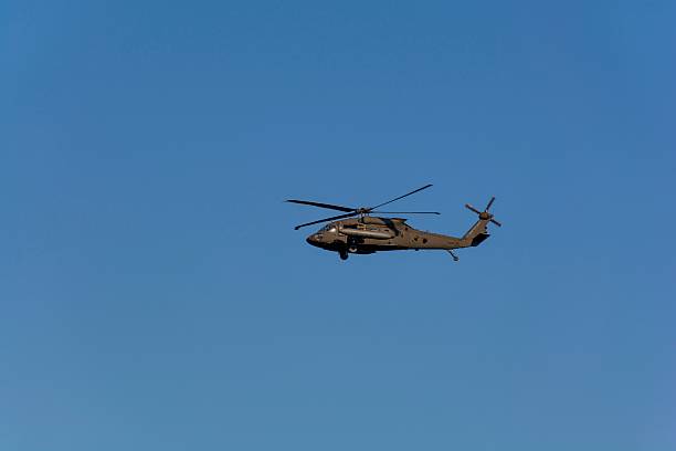 istock Military helicopter flying against blue sky 598684284