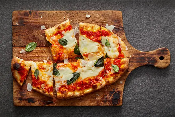 Photo of neapolitan pizza on rustic wood and stone