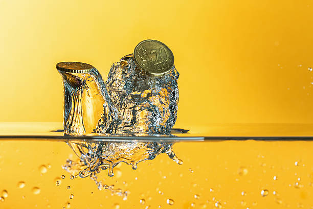 istock Euro coins with water splash on  yellow background 598688384