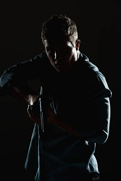 istock Man in action with handgun 598691728