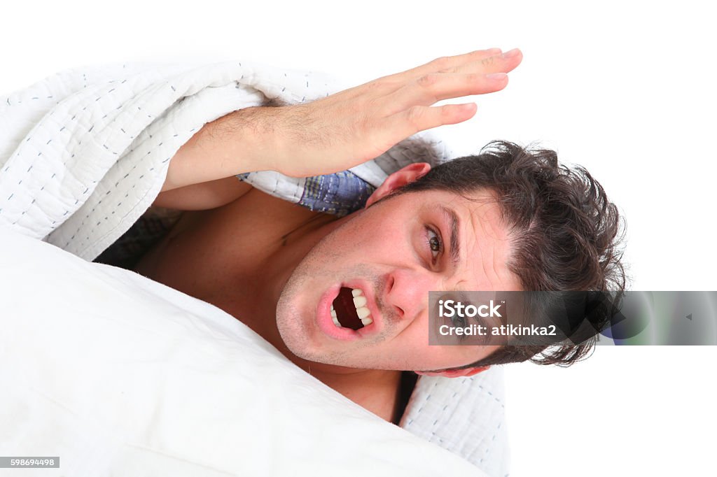angry man lying in bed angry man  lying  in bed on white background Adult Stock Photo