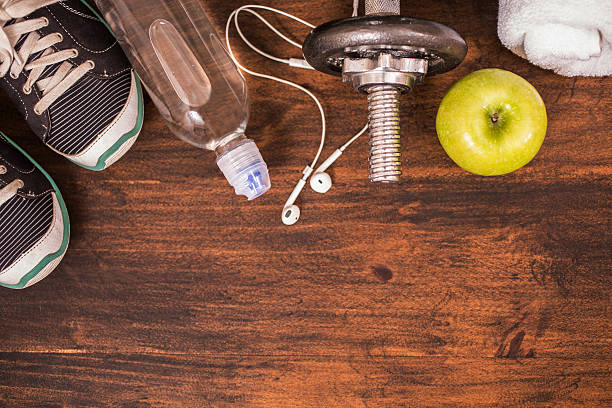 istock Fitness, exercise themed scene with barbells, sneakers, apple. 598698780