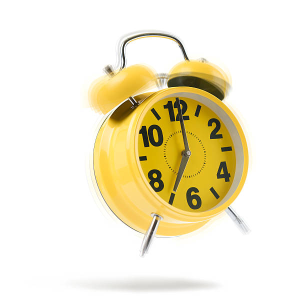 istock Yellow alarm clock rings in the morning on white. 598700652