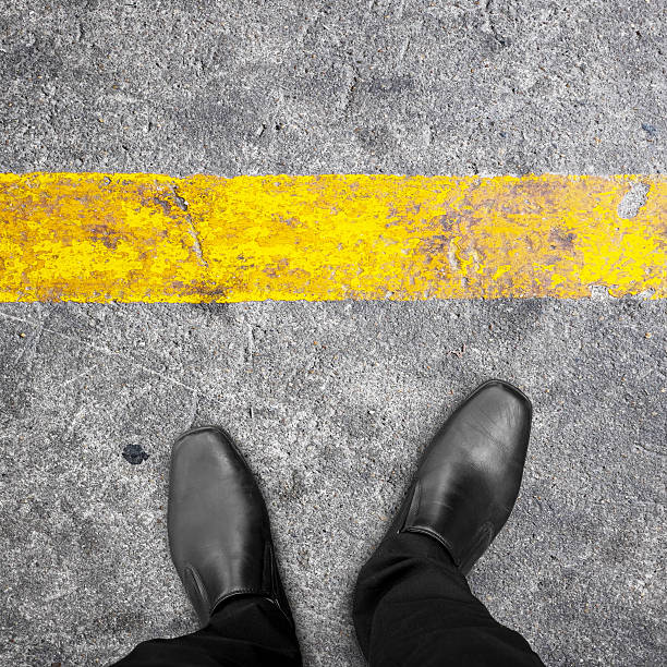 istock Black shoes standing at yellow line 598702086