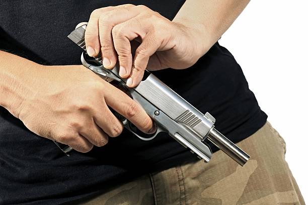 Man hold and loading ammunition his pistol Close up of man's hand reloading gun, Man hold and loading ammunition his pistol on white background. Army, Semi-automatic handgun, 45 pistol. forty five caliber handgun stock pictures, royalty-free photos & images