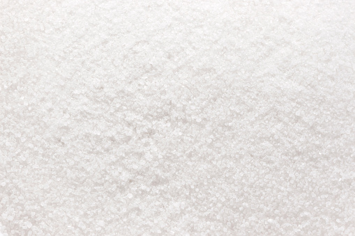 Granulated white sugar texture or background, top view