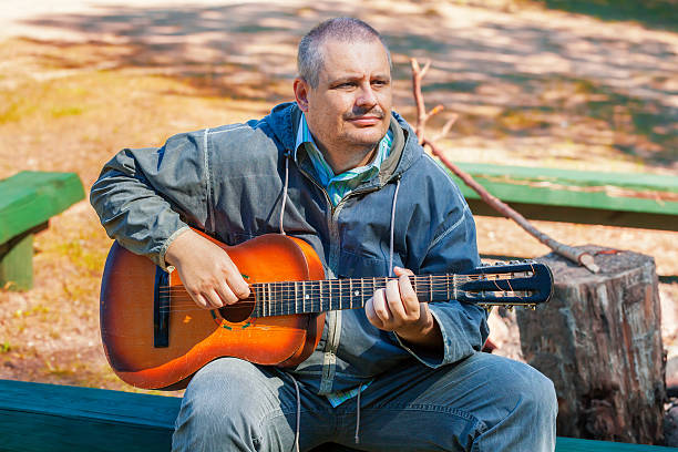 istock Hiker playing guitar near the fire site 598703772
