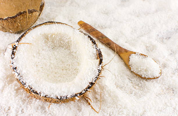 cocco fresco dimezzato e polvere sul tavolo - powdered coconut foto e immagini stock