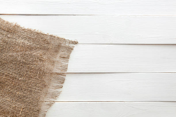 istock Burlap on white wooden background 598704066