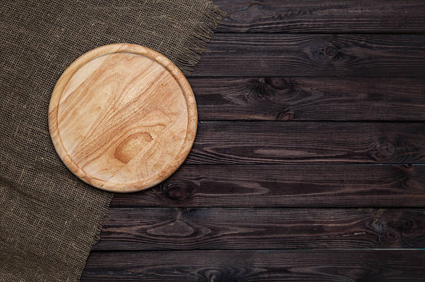 istock Round cutting board on dark wooden table 598704646