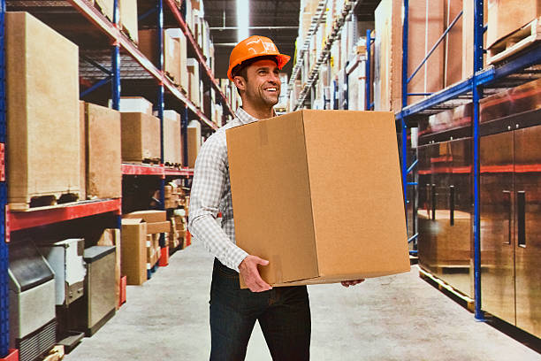 istock Smiling manager holding box in warehouse 598705026