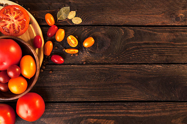 istock Tomatoes on wooden table background, top view 598705056