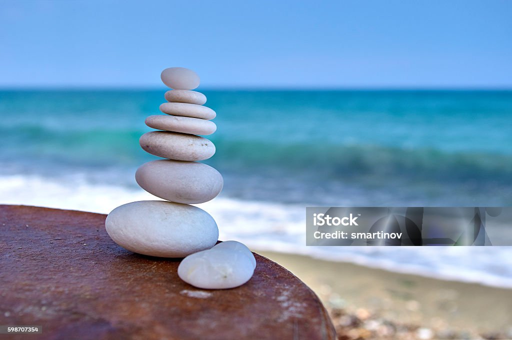 Pile of white rocks on a table near the sea Pile of white rocks on a table near the sea shore Consoling Stock Photo