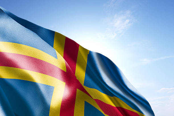 Flag of Aland waving in the wind Flag of Aland waving in the wind. Blue sunny sky in the background. Horizontal orientation. åland islands stock pictures, royalty-free photos & images