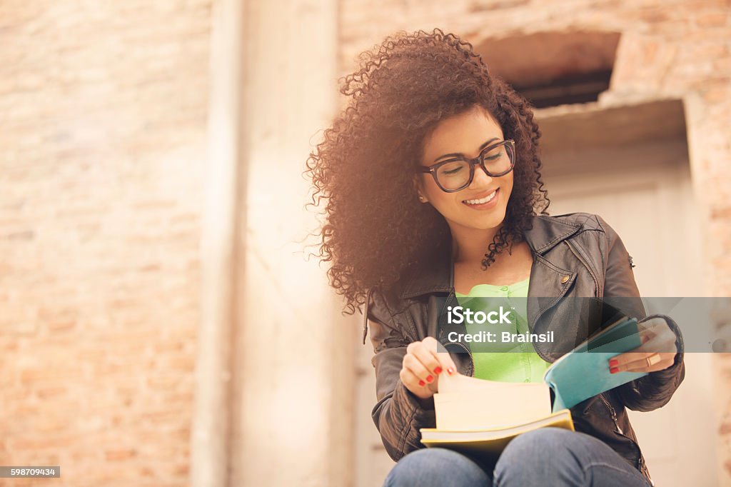 Mujer joven afroamericana con libros - Foto de stock de Estudiante de universidad libre de derechos