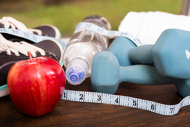 istock Fitness, exercise themed scene with weights, sneakers, apple. 598709544