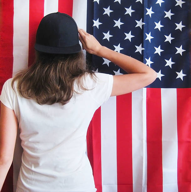 istock Young hipster girl turned back on american flag background 598710062