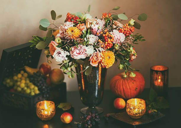 Autumn still life Autumn still life with flowers, pumpkin, fruits and candles. Toned,vintage style rose bouquet red table stock pictures, royalty-free photos & images