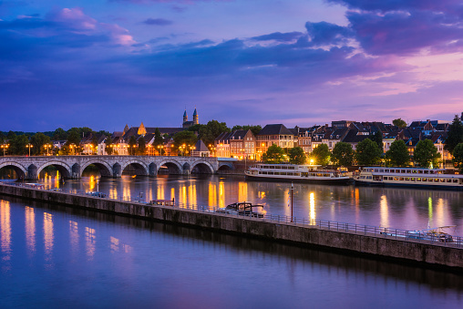 Maastricht, Netherlands with 13th Century Sint Servaas bridge and Maas River around sunset.