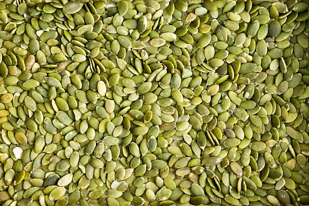 Background texture of fresh healthy green de-husked pumpkin seeds a popular snack and salad ingredient rich in protein and nutrients