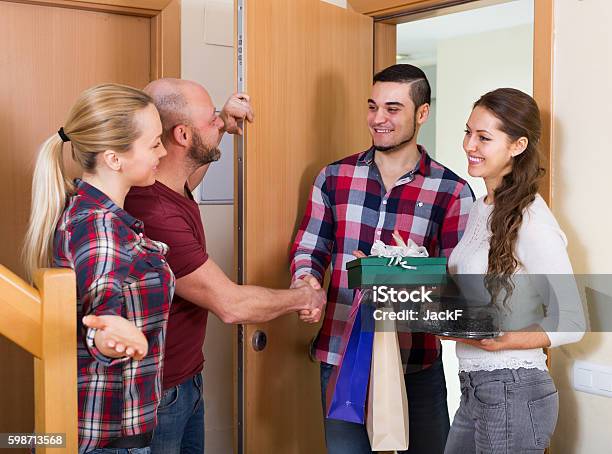 Warm Welcome Of Joyful Friends Stock Photo - Download Image Now - Greeting, Guest, Gift